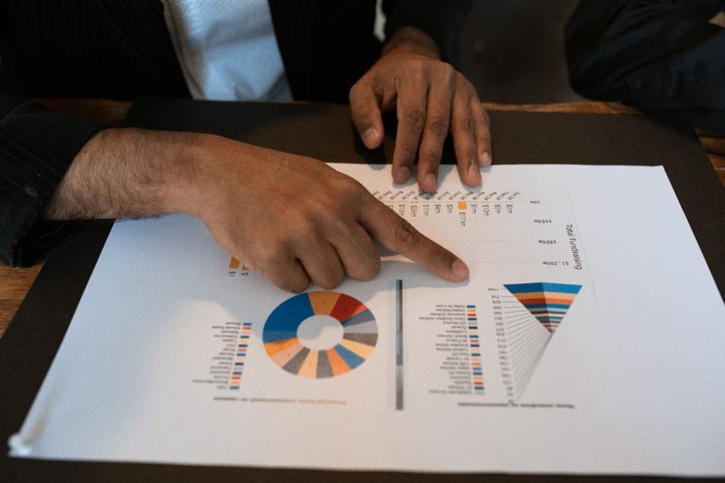 Two people reviewing a printed data analysis report with charts