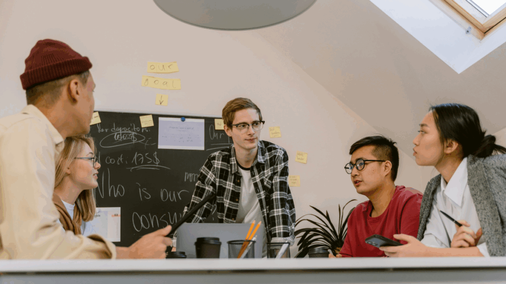 A group of people sit around a table discussing a topic.