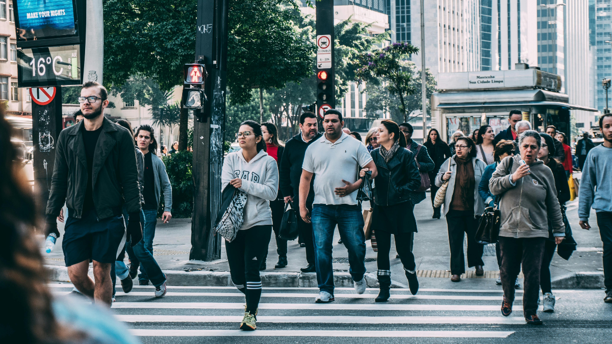 Crowd of diverse people crossing a busy city street, representing how noise is part of the truth when modeling human behavior.